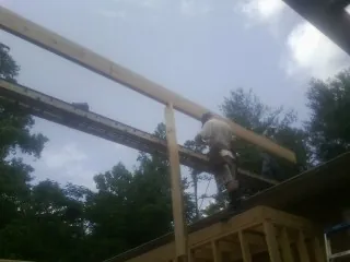 Carpenter setting a ridge beam over a new addition frame — Ice Dam Removal by Roofing Brothers in Westchester