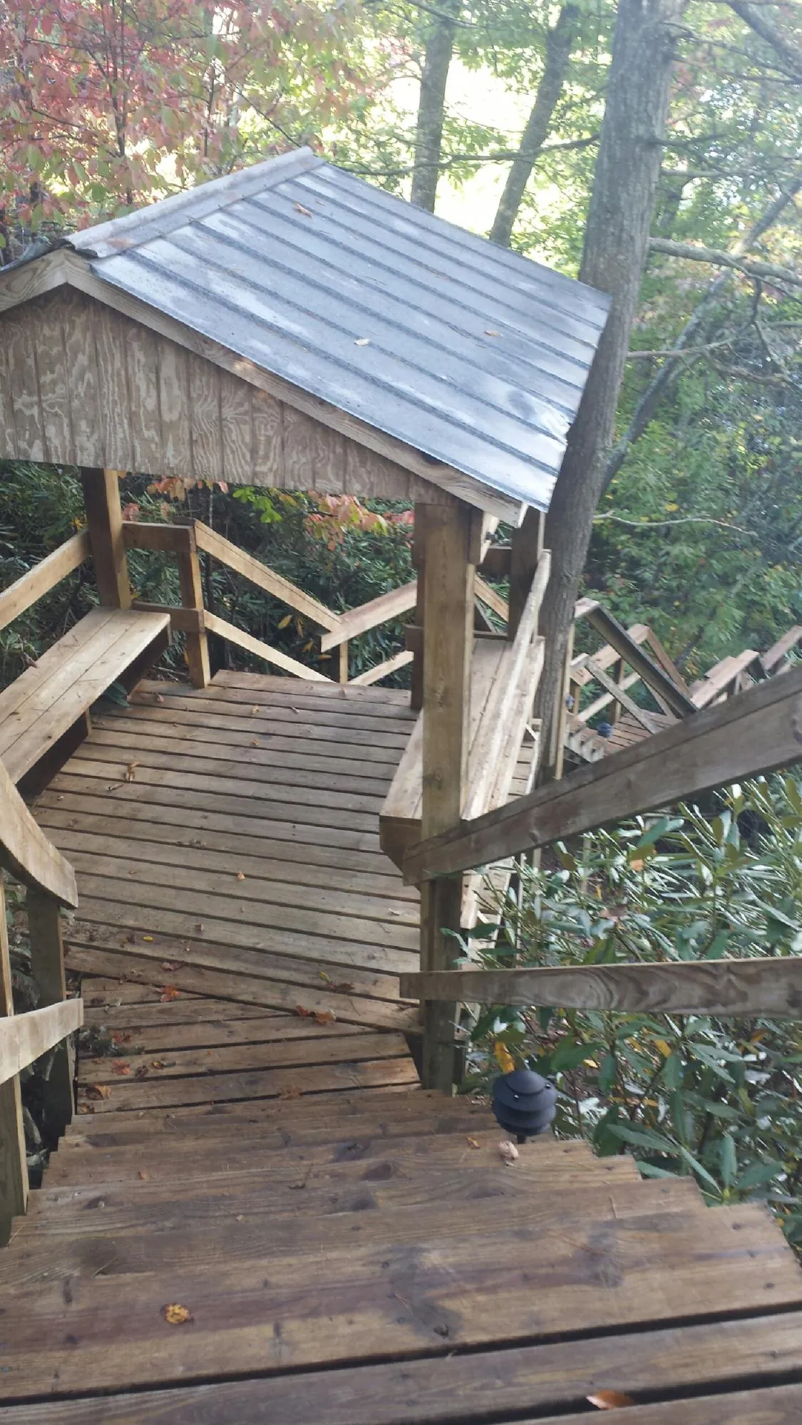 Metal roofed shelter over wooden steps on a wooded walkway — Skylight Repair & Installation work by our crew in Westchester
